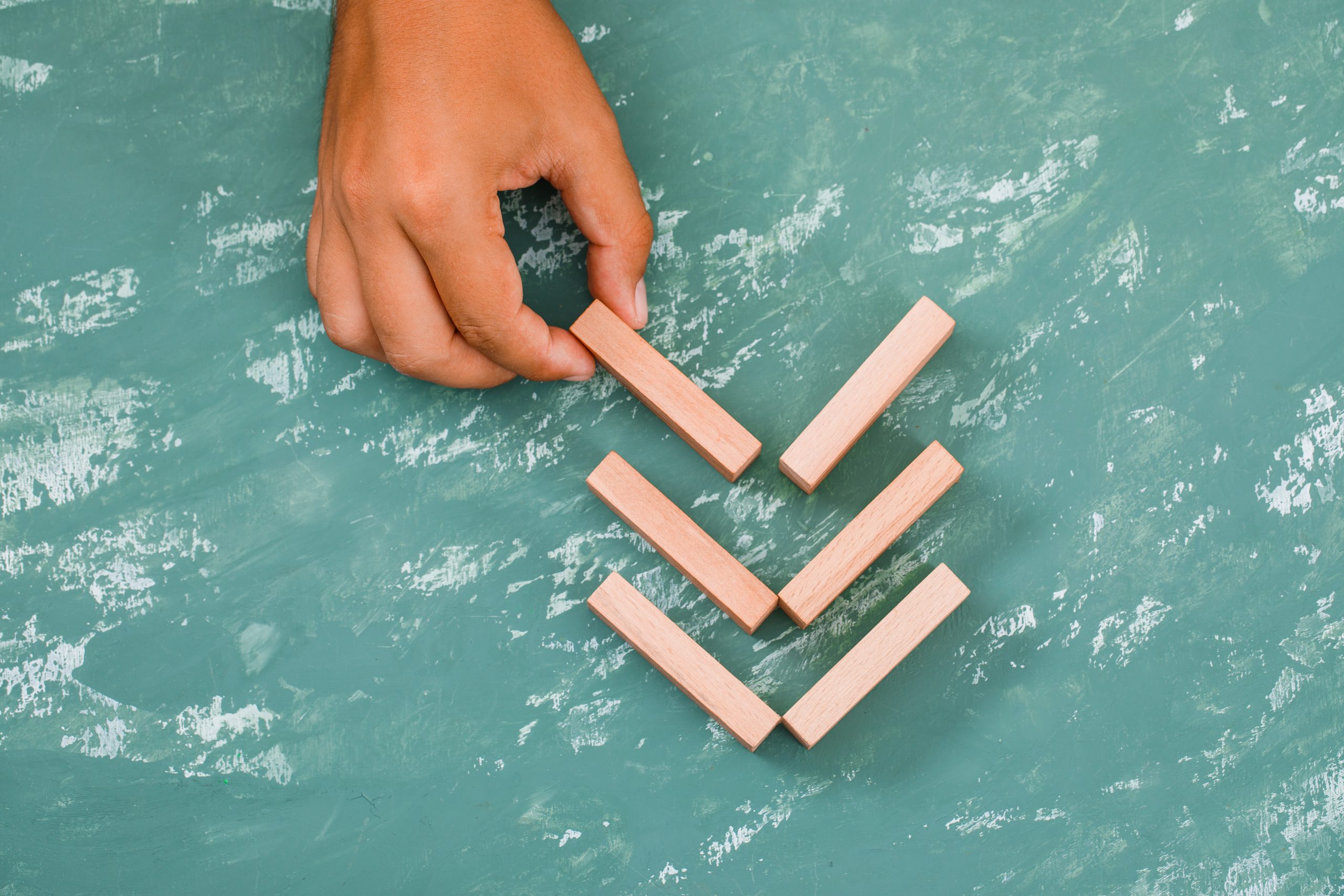 Business strategy concept on plaster background flat lay. hand placing wooden block.